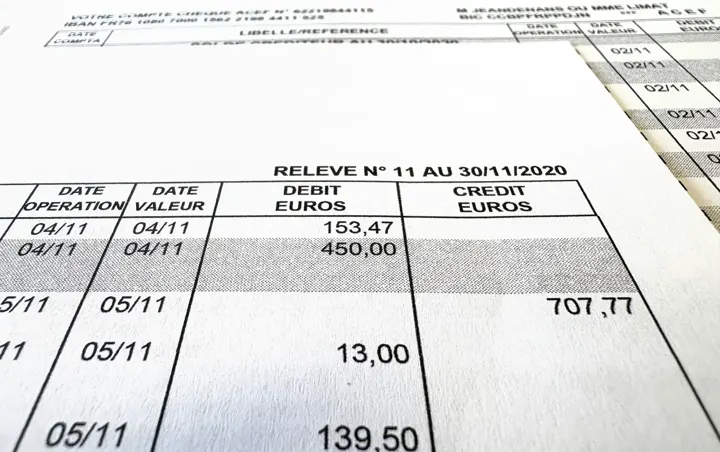Gros plan sur un relevé de compte bancaire imprimé, avec ses lignes de transactions et ses montants